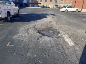 This parking lot has pot holes caused by weather conditions.